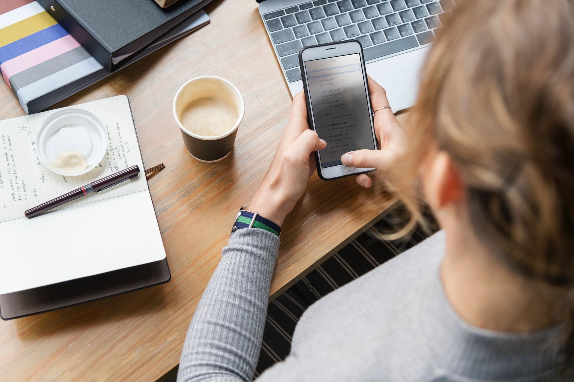a person sitting at a table using a mobile phone